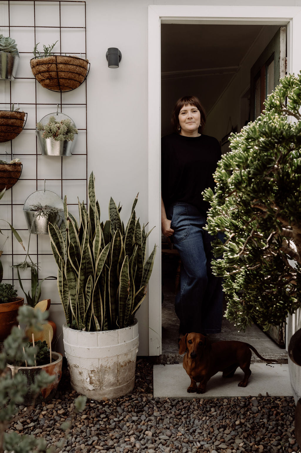 Lyndel Henry & Gary the dachshund standing in the doorway of the Henry & Tunks ceramic studio