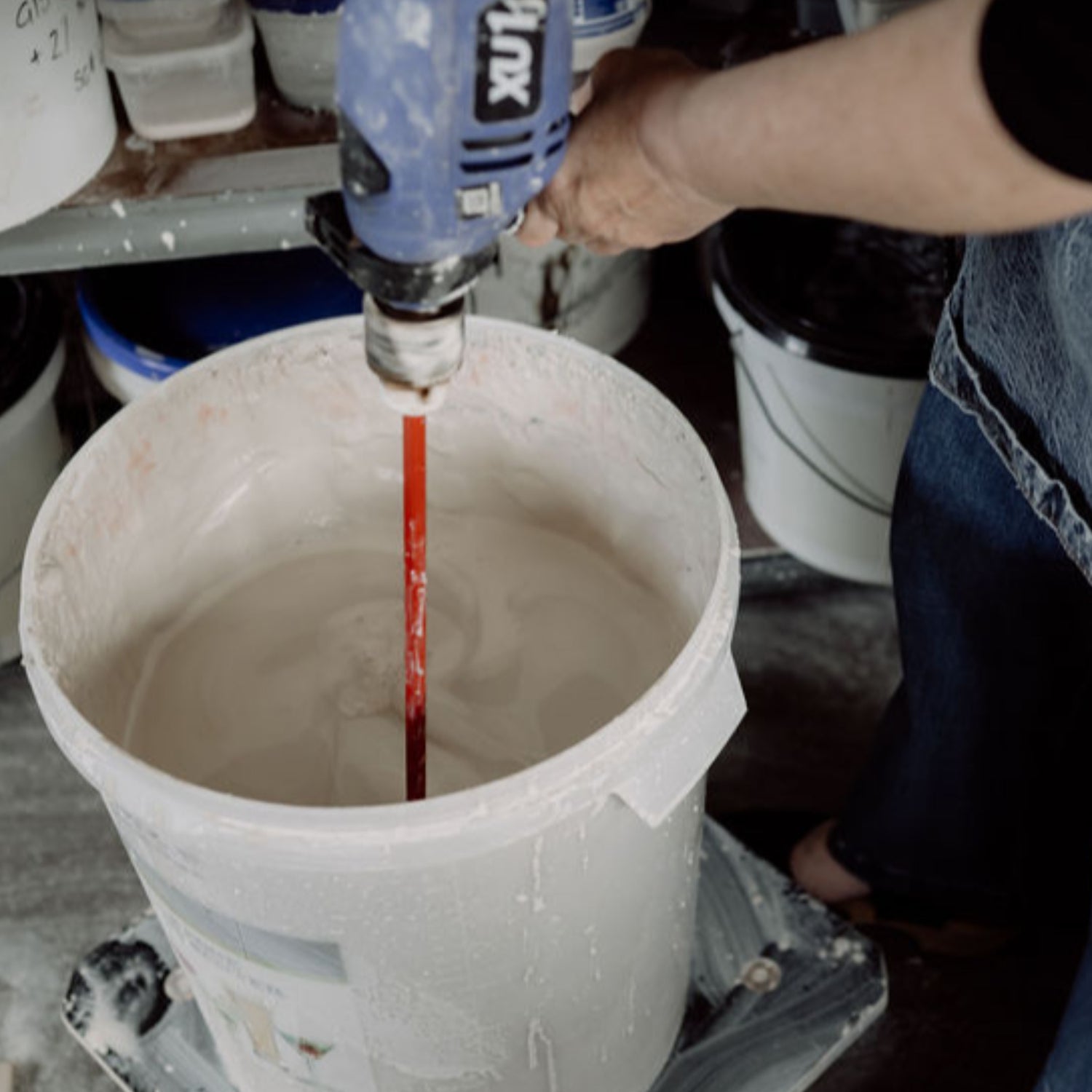 preparing clay slip with a drill and paint mixer attachment in the Henry & Tunks ceramic studio