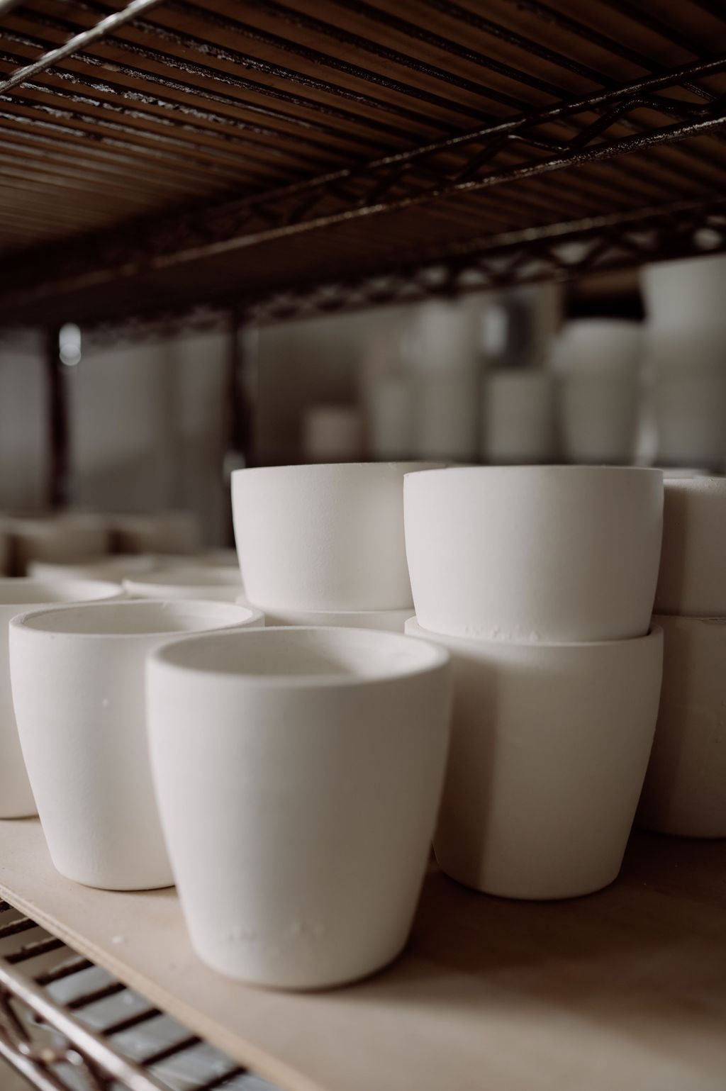 unfired clay cups on a shelf in the Henry & Tunks ceramic studio